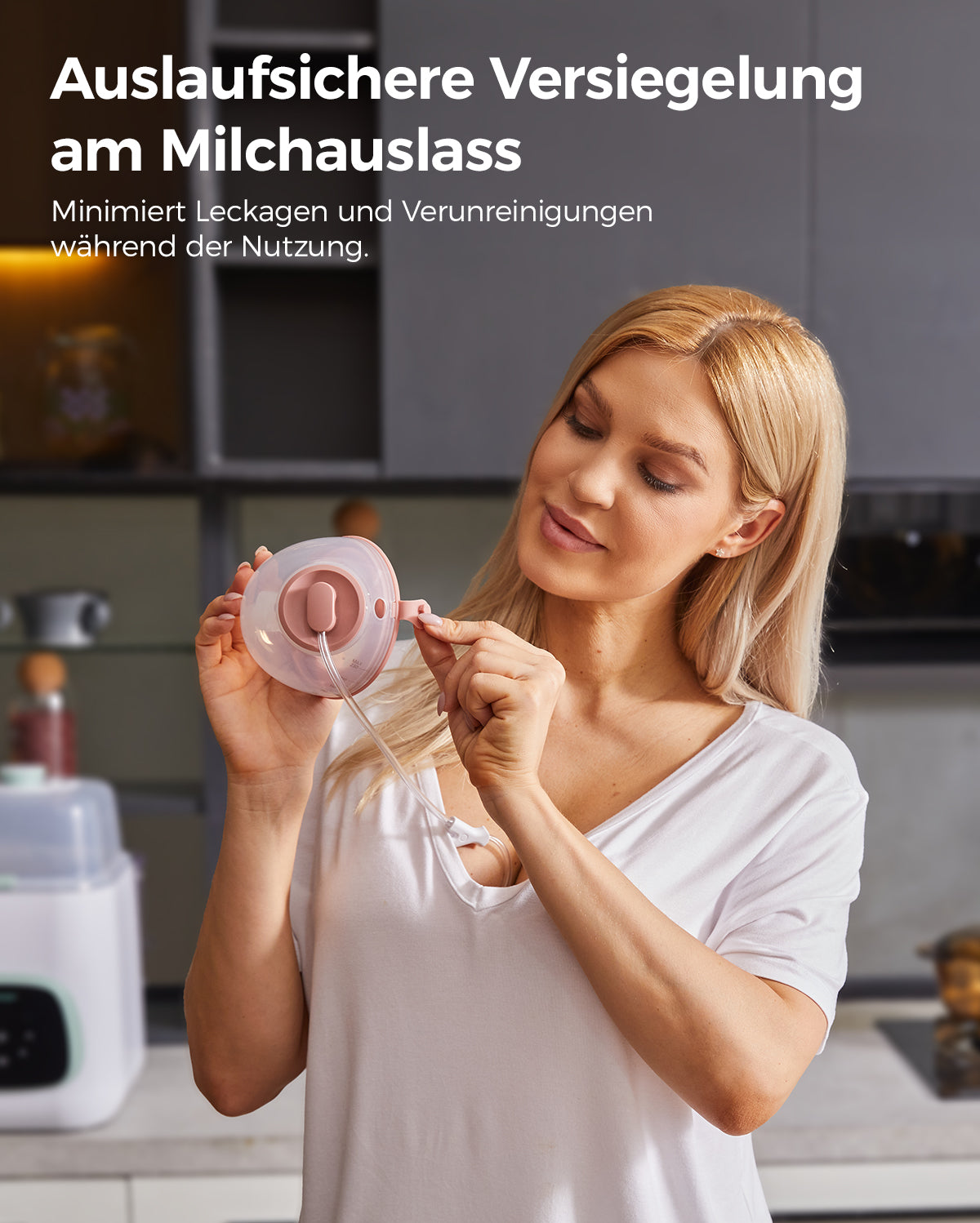 Woman demonstrating leak-proof seal on breast pump's milk outlet in a kitchen.