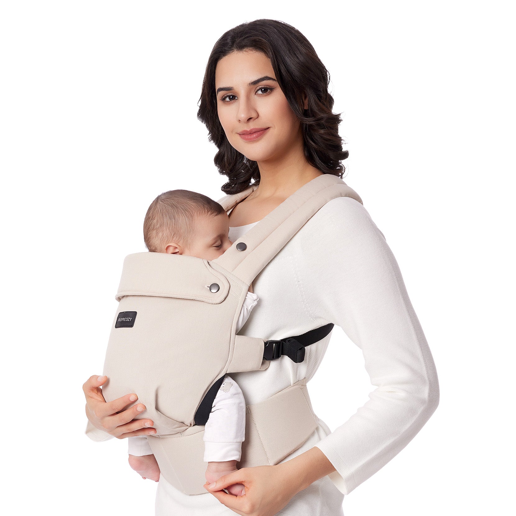 Woman in white top wearing Khaki Momcozy ergonomic baby carrier with infant.