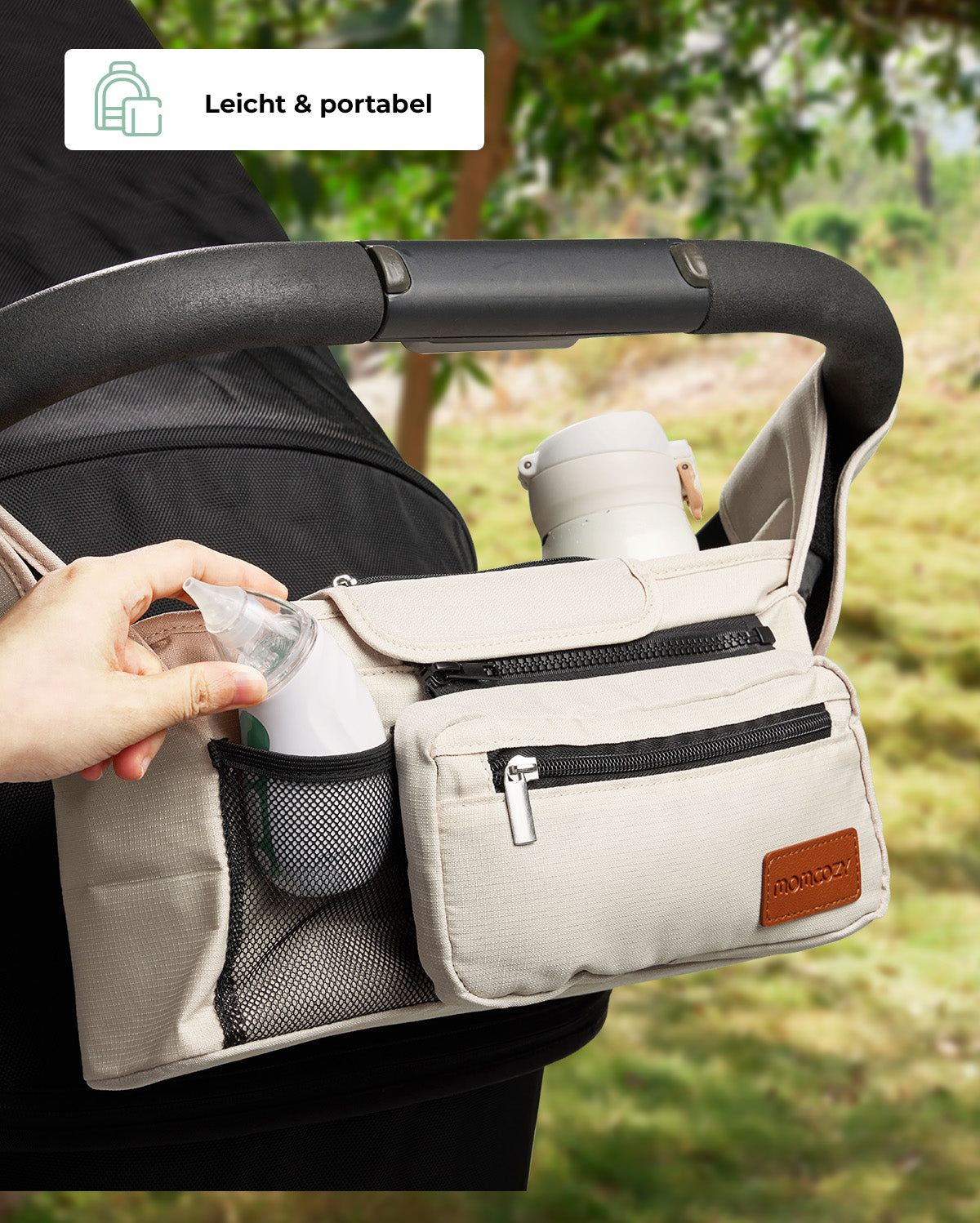 Momcozy stroller organizer bag with pockets for bottles and essentials in outdoor setting.